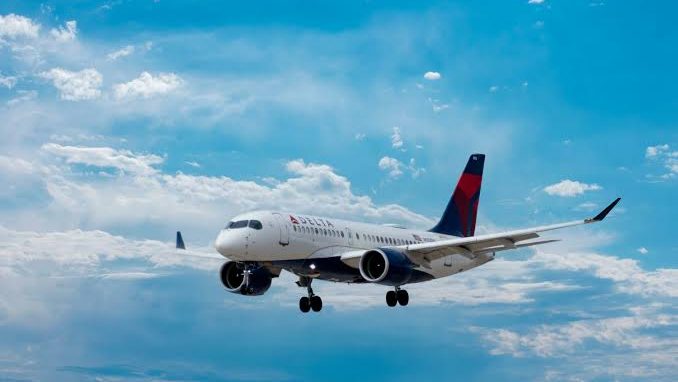 Commercial passenger airplane flying high through blue skies and white clouds, illustrating the complex landscape of federal travel regulations and whether medical marijuana is allowed on planes.